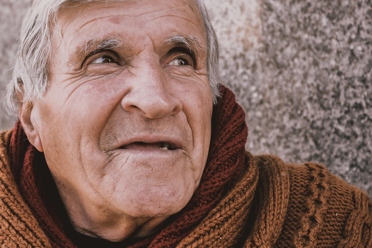 Senior patient smiling — full dentures vs implant-supported dentures